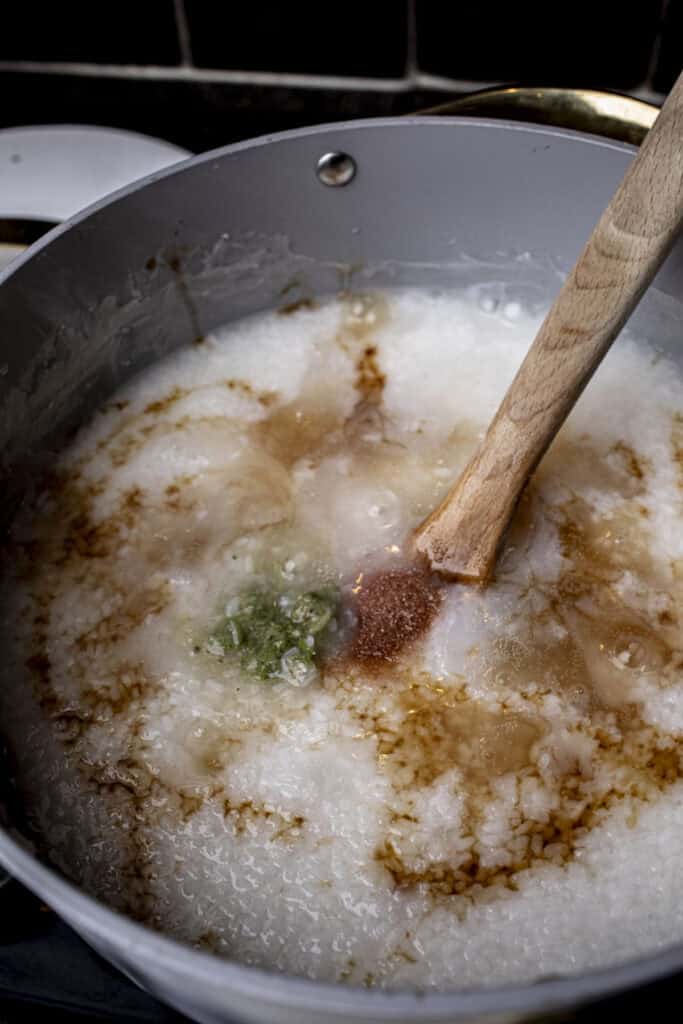Seasoning sauces in rice porriage in a pot.
