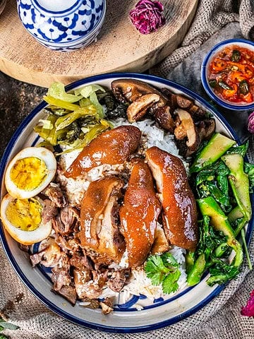 Khao Khao Moo on a platter with garnishes.