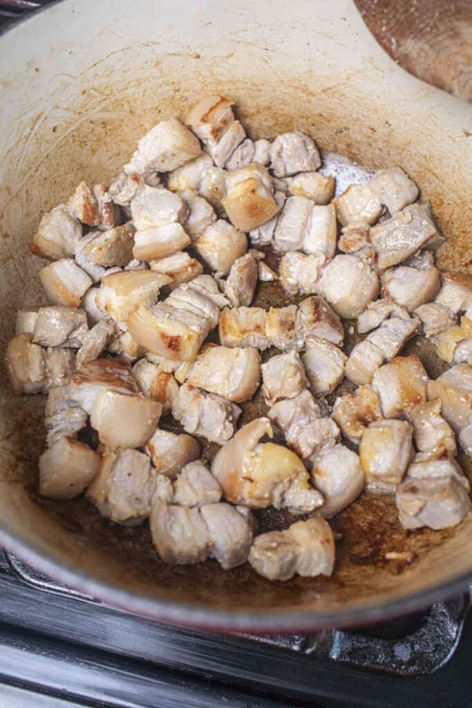 Pork belly cubes in a dutch oven.