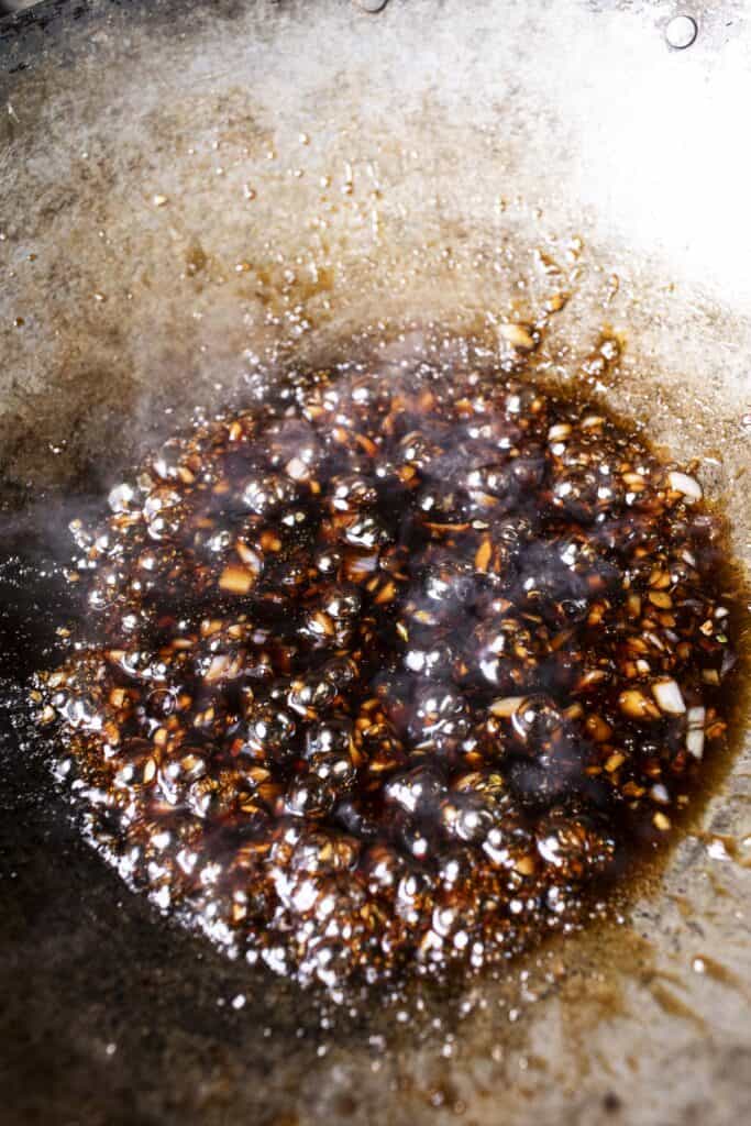 Dark Kua mee sauce in a wok.