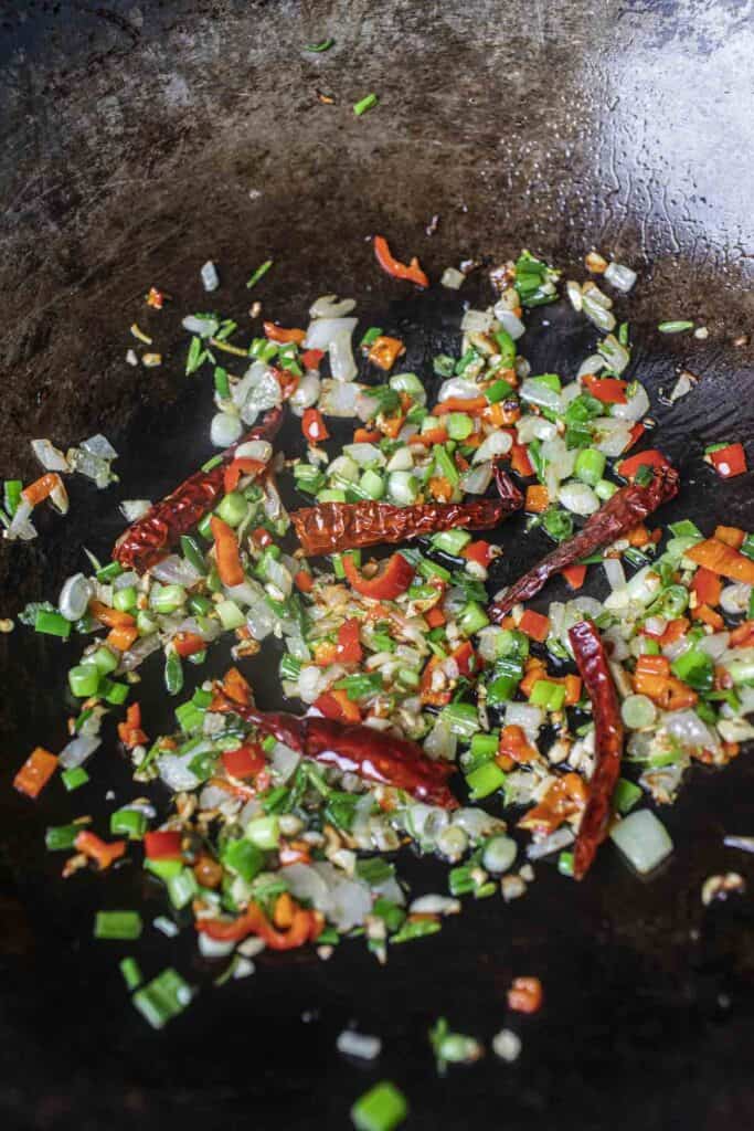 Fried aromatics with chilis in a wok. 
