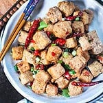 Salt and pepper tofu on a plate with chopsticks on the side.