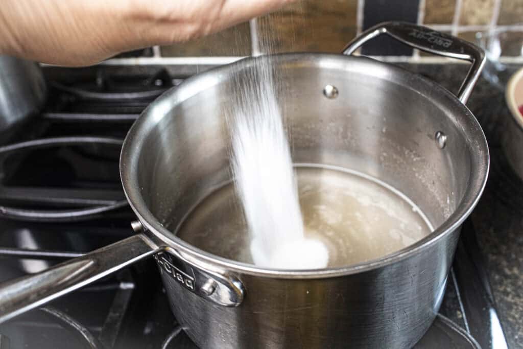 Sugar pouring into a pan with agar powder.