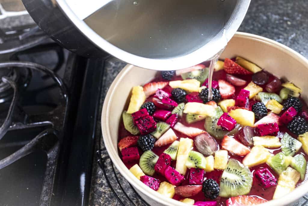 Water pouring into a pan of fruit.