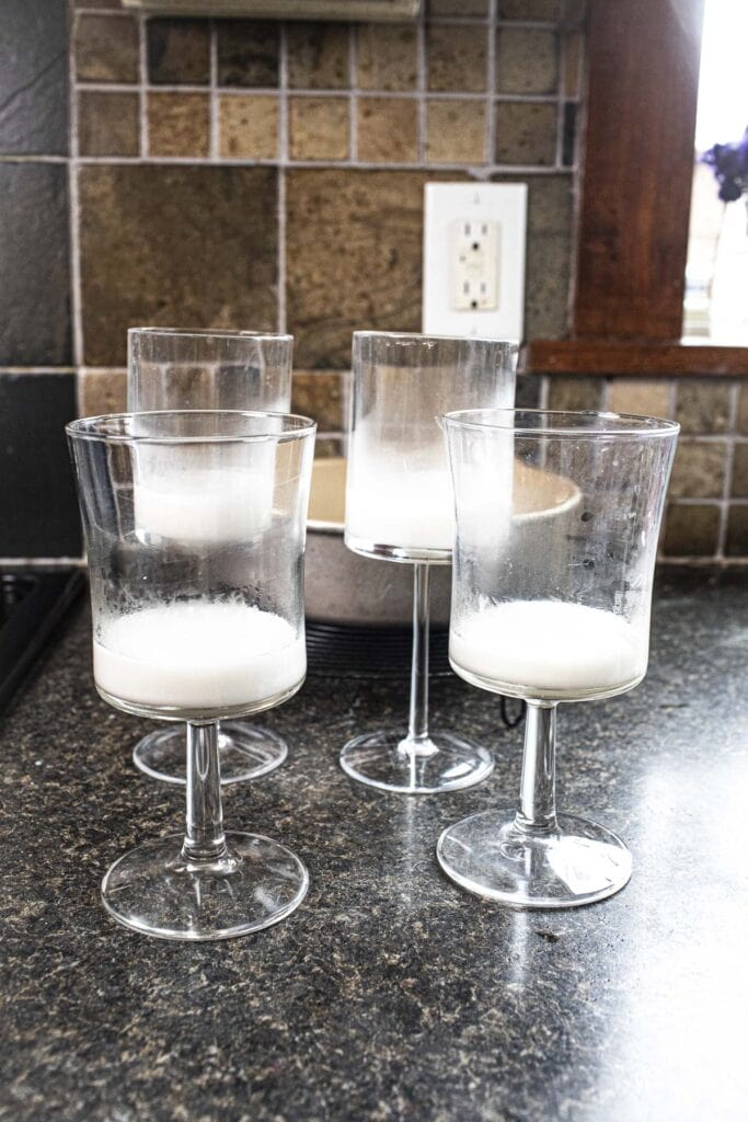 Coconut jello inside 4 glasses on a table. 
