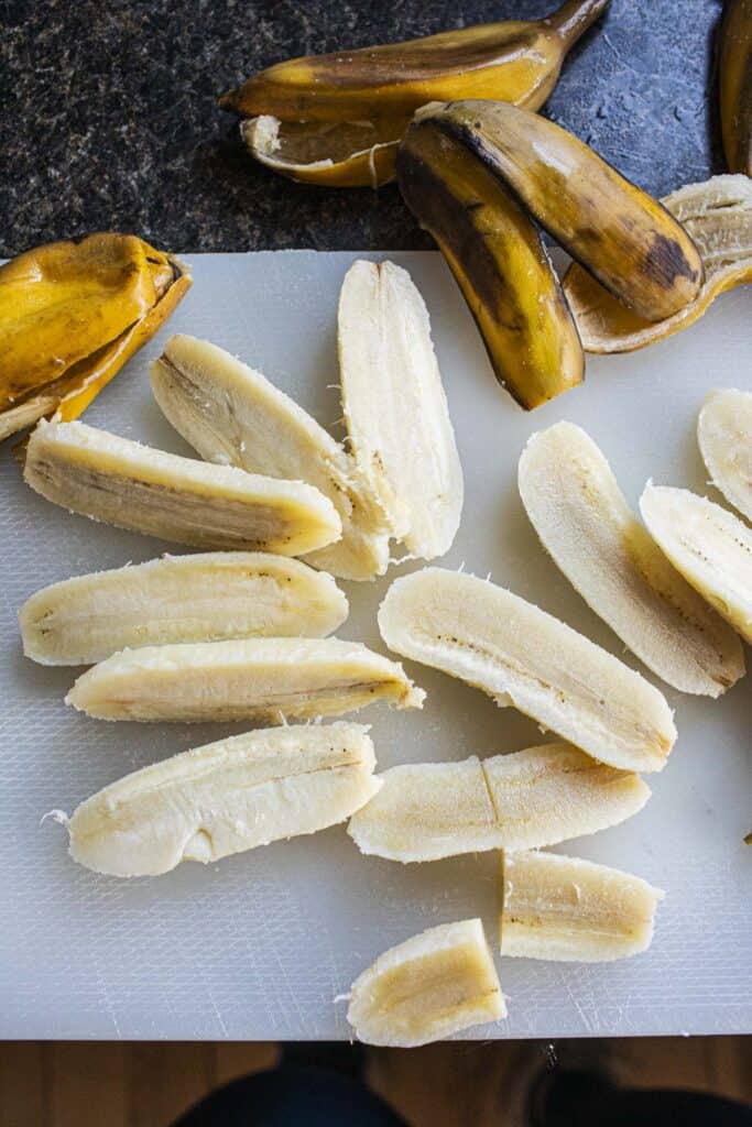 Peeled and sliced bananas on a cutting board. 