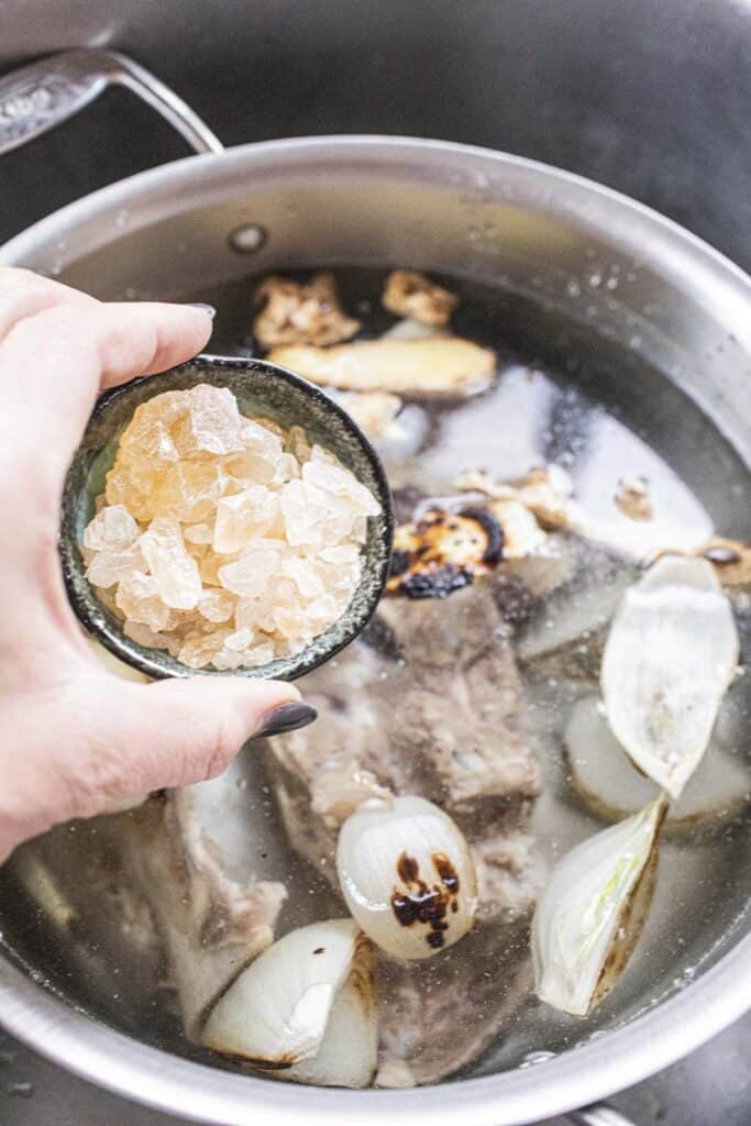 rock sugar pouring into pho broth.