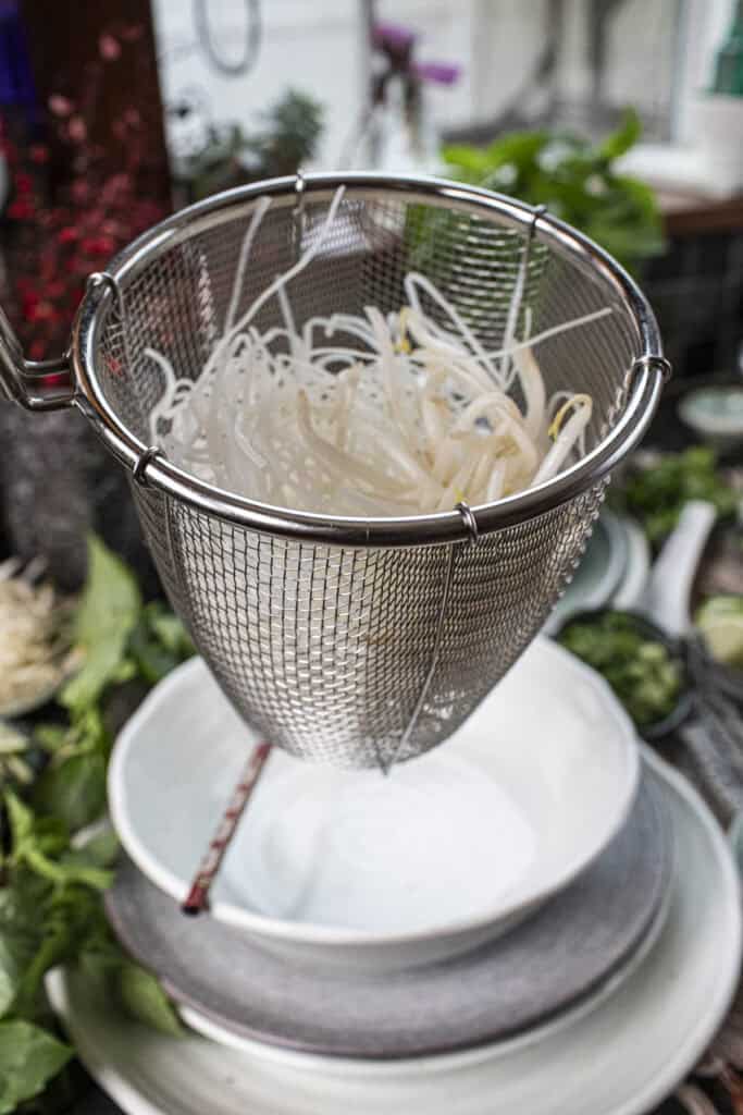 Rice Noodles in a wire mesh strainer.