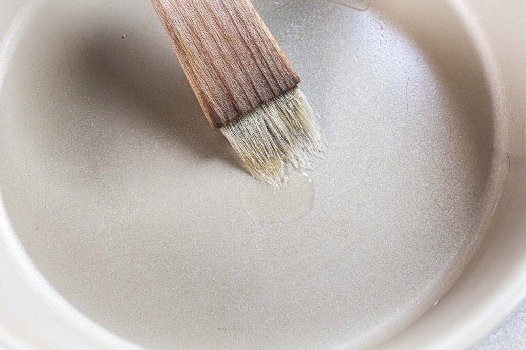 A brush with oil on a pan surface. 