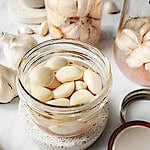 thai pickled garlic in a class jar on the table.