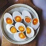 cooked and sliced salted eggs on a plate.