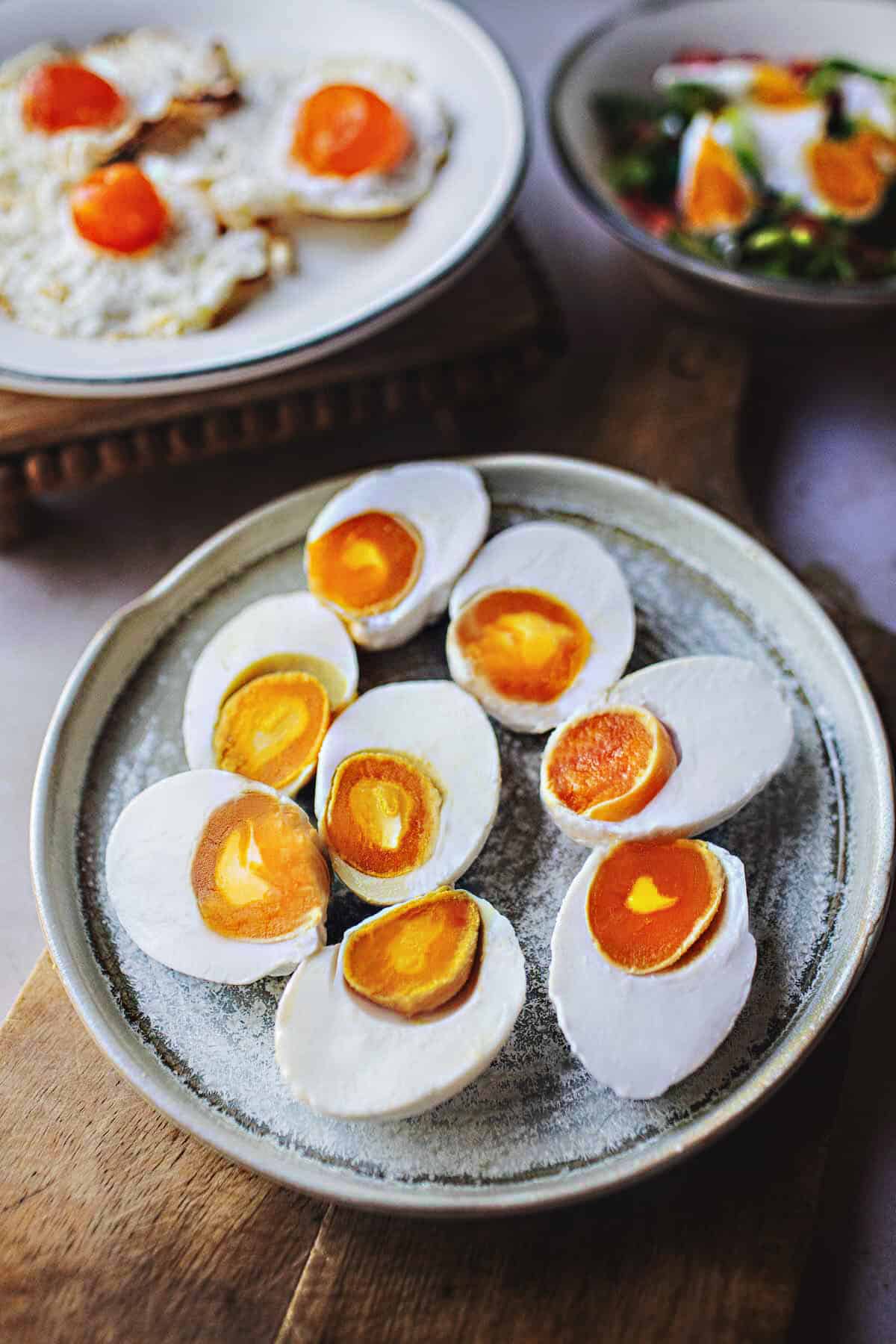 Sliced salted duck eggs in halves on a plate.