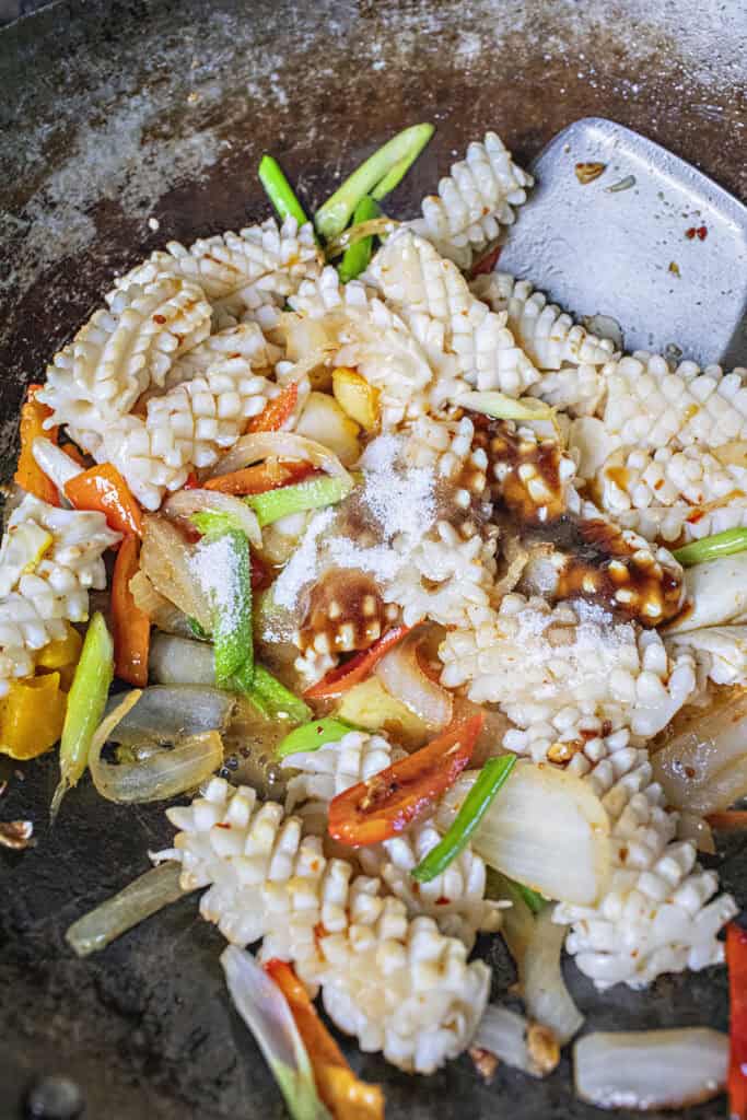 Thai Salted egg squid stir fry in a wok.