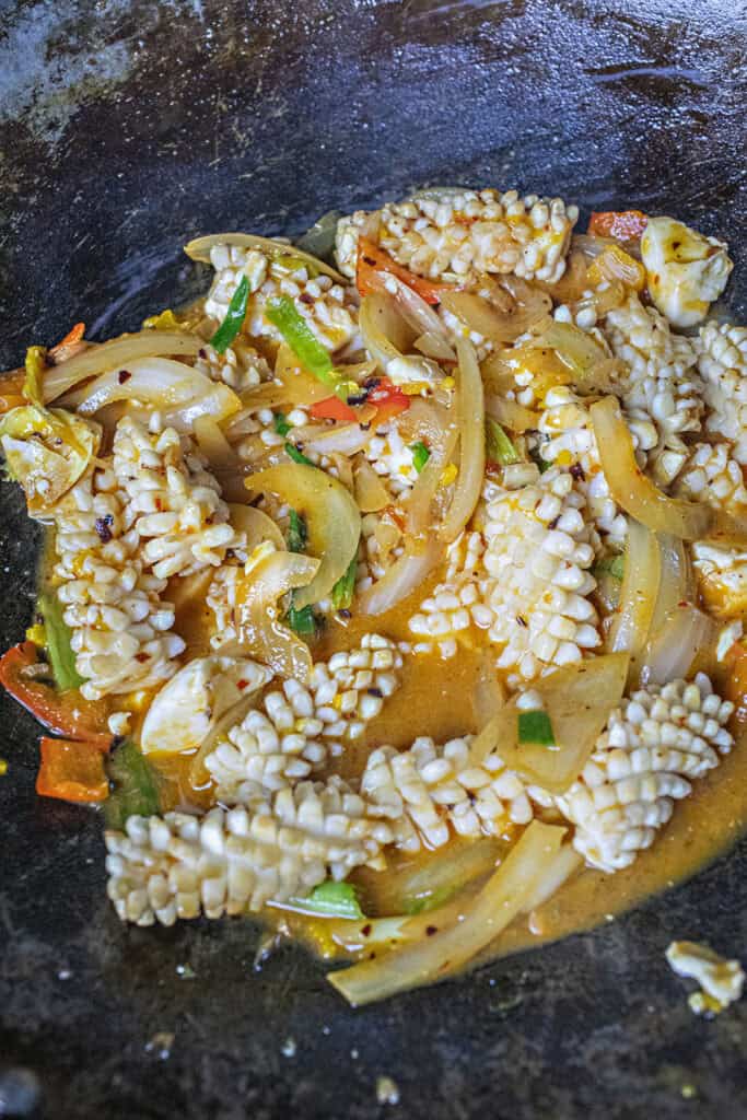Salted egg squid stir fry in a wok.