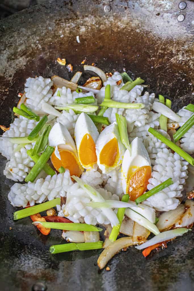 Thai Salted egg squid stir fry in a wok.