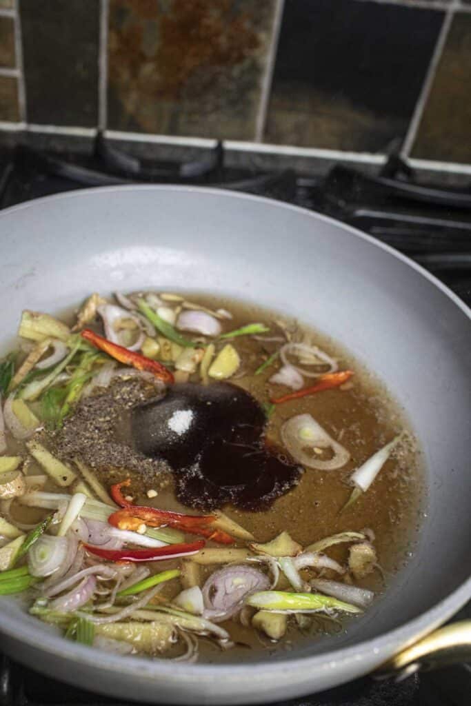 Soy sauce and aromatics in a pan.
