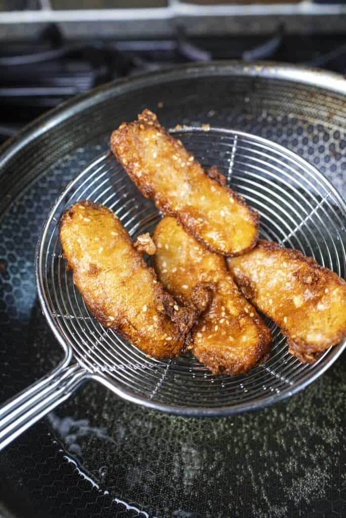 thai fried bananas in a wire mesh rack.