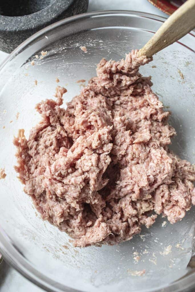 Ground meat in a glass bowl. 