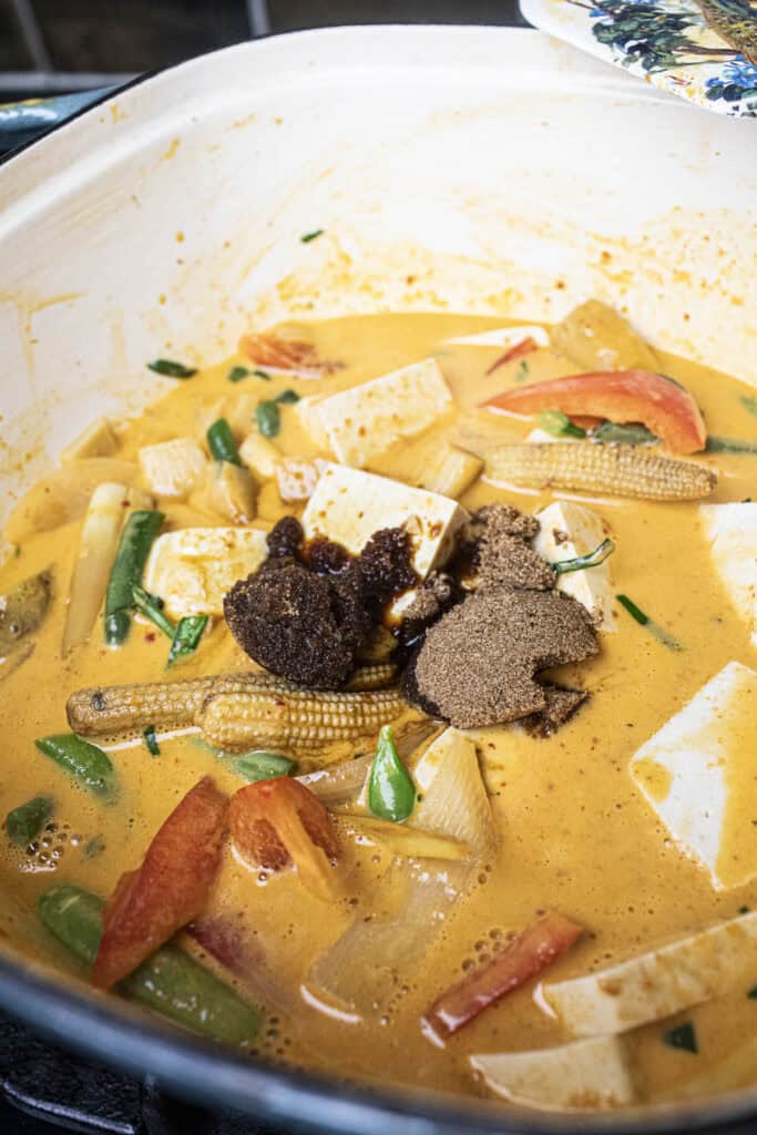 Thai red curry with sugar, tofu and vegetables in a pot.