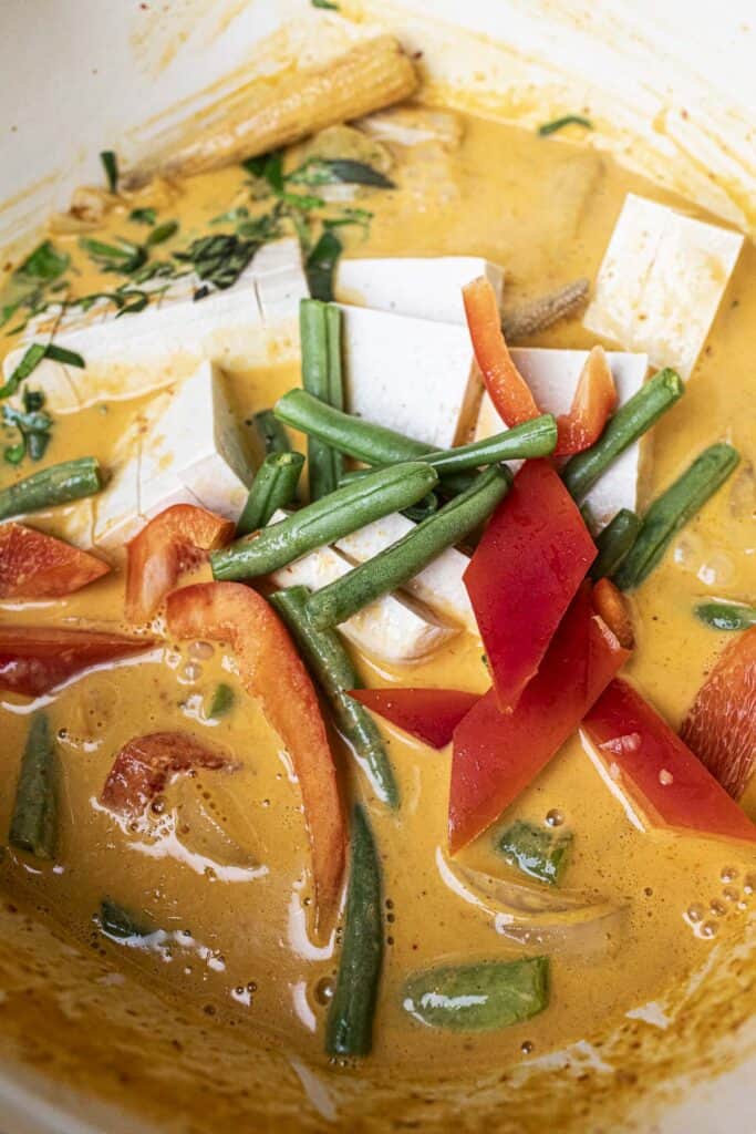 Vegan Thai red curry tofu and vegetables in a pot.