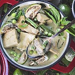 vegan thai green curry in a red bowl.