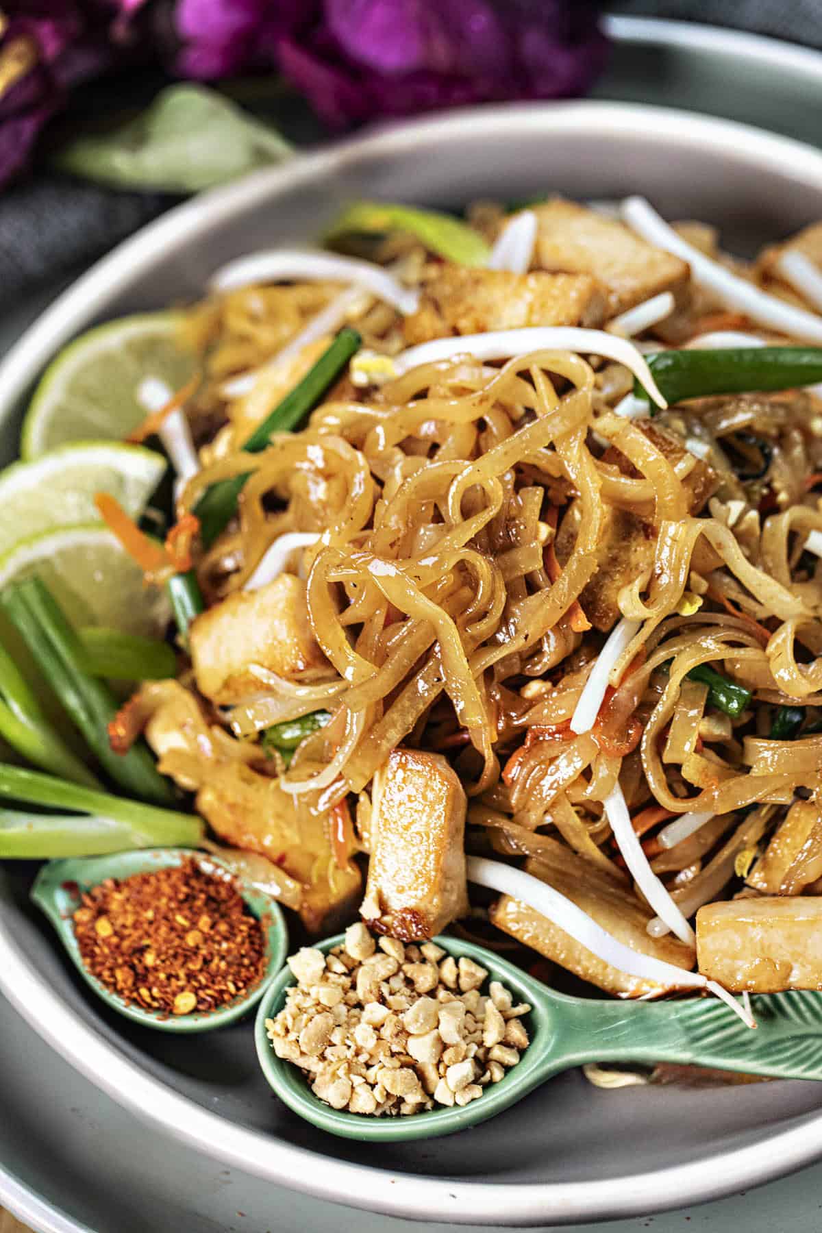 Pad Thai noodles with garnishes on a plate on the table. 