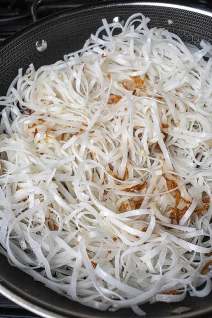 Pad Thai noodles in a wok with aromatics.