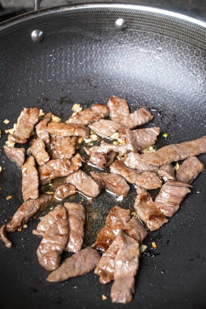 Sliced beef for pad see you stir fry in a wok.