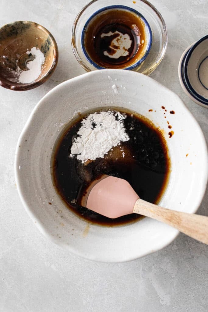 Sauces mixed together in a bowl with a spatula. 