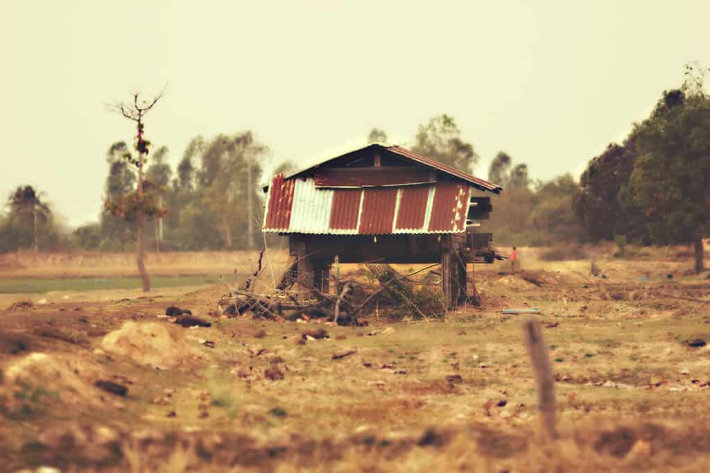 A rustic Thai hut in the middle of a rice fiedl.
