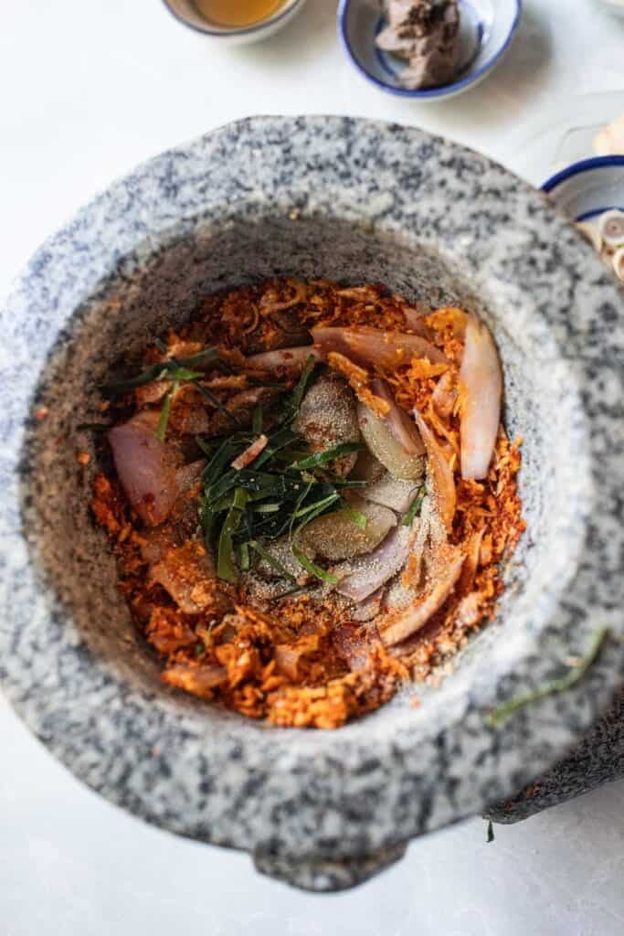 Southern Thai curry paste ingredients are ground in a stone mortar and pestle. 