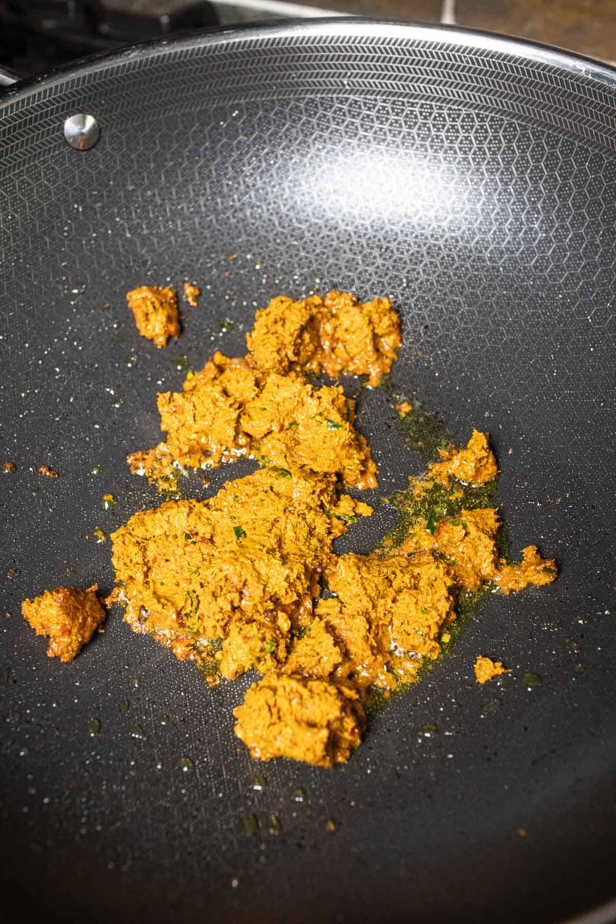 khua kling curry paste frying in a wok. 