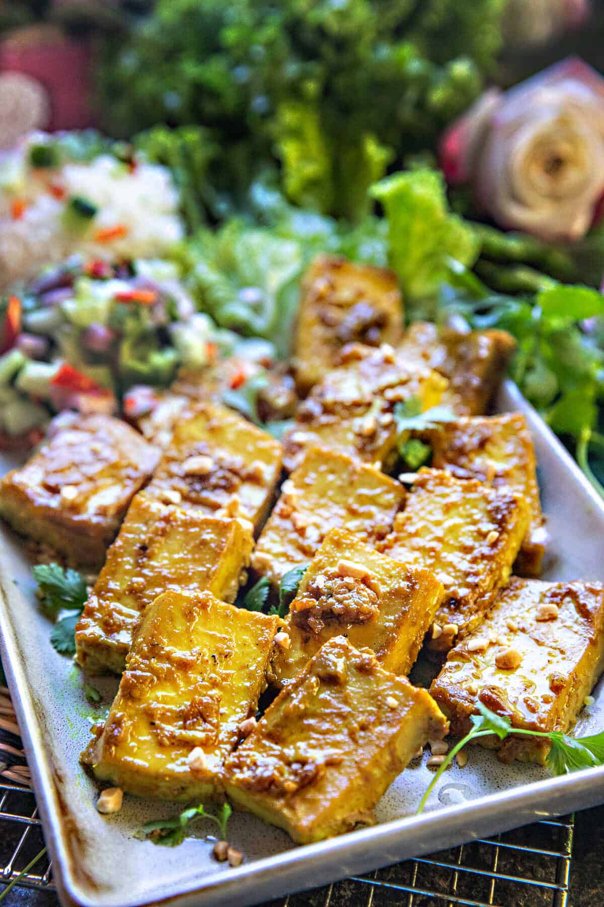 Satay tofu pieces on a platter with lettuce.