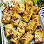 tofu satay on a tray with lettuce and rice