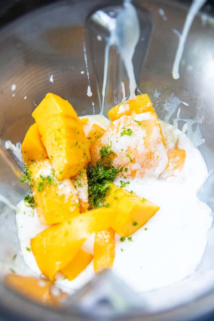 Mango chunks, coconut cream, and lime zest in a blender. 