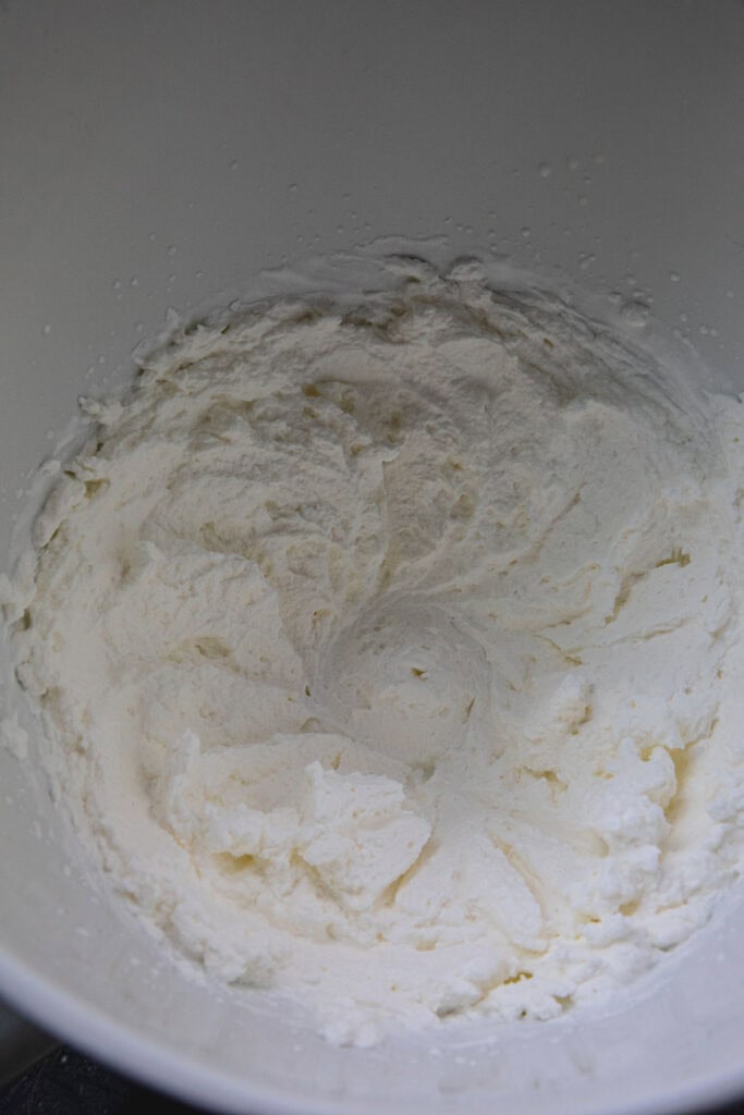 Heavy whipped cream inside a mixing bowl. 