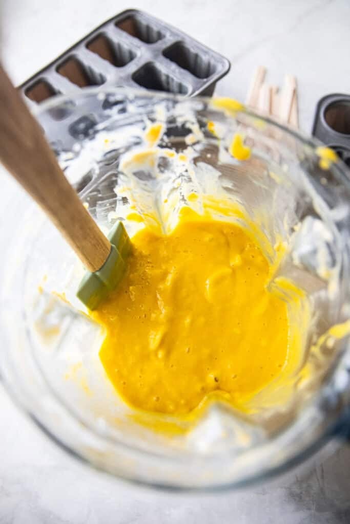A spatula in a pureed mango with a food processor. 