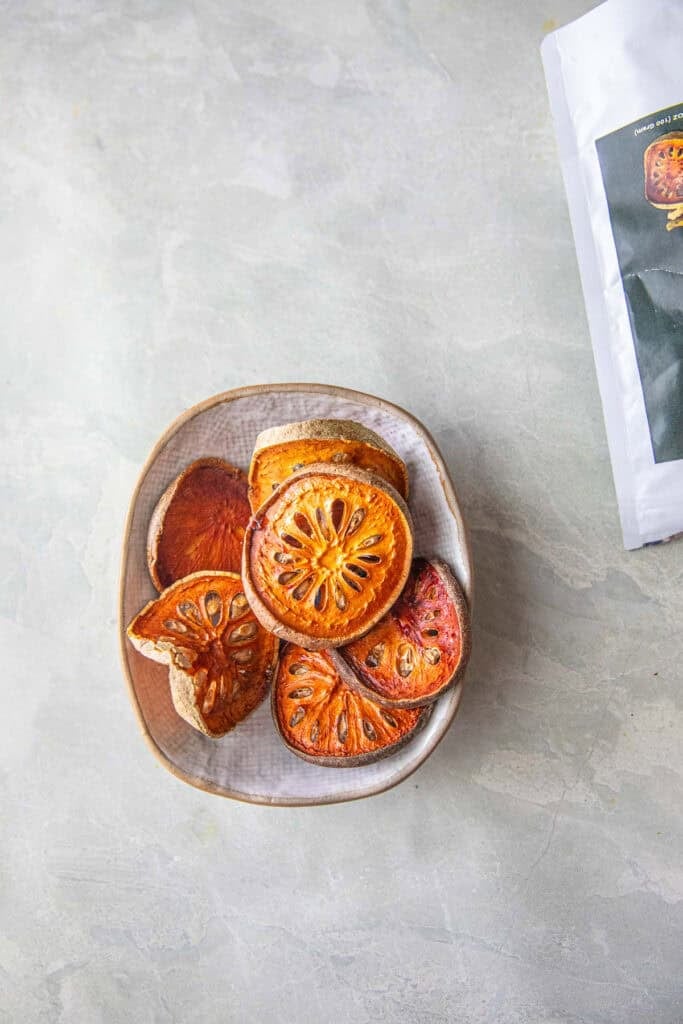 Dried Bael fruit slices on top of a bowl. 