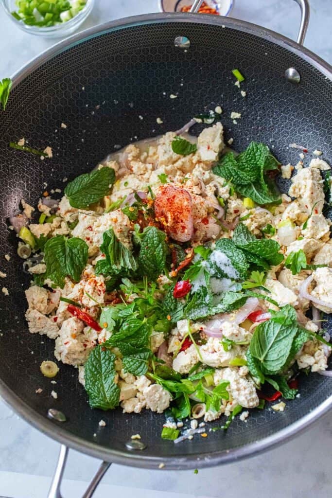 A pile of tofu larb recipe vegetarian with mint leaves on top. 