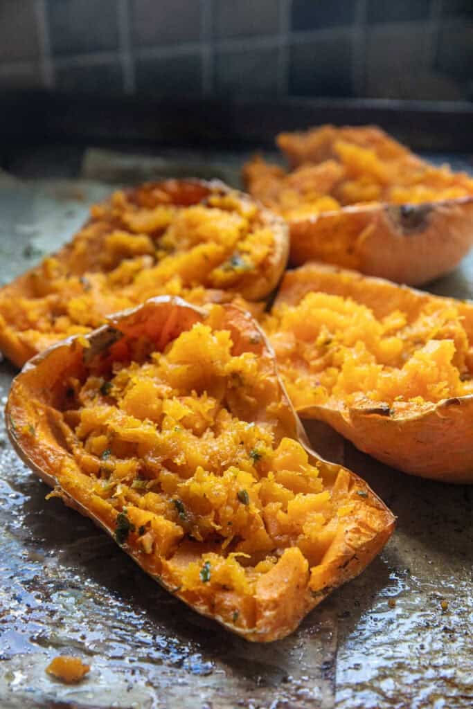 Scraped baked Butternut squash flesh into halves of butternut on a baking tray.  