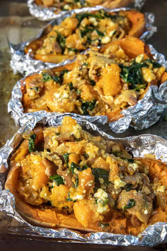 Butternut squash stuffing in half a butternut squash with foil lining on the sides. 