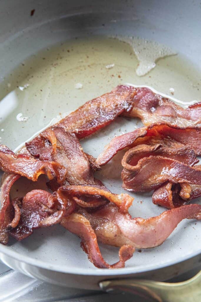 Cooked bacon slices in a pan.