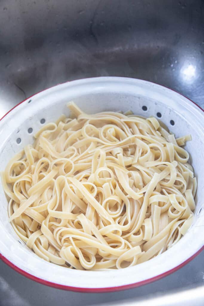 Pasta in a colander in a sink.