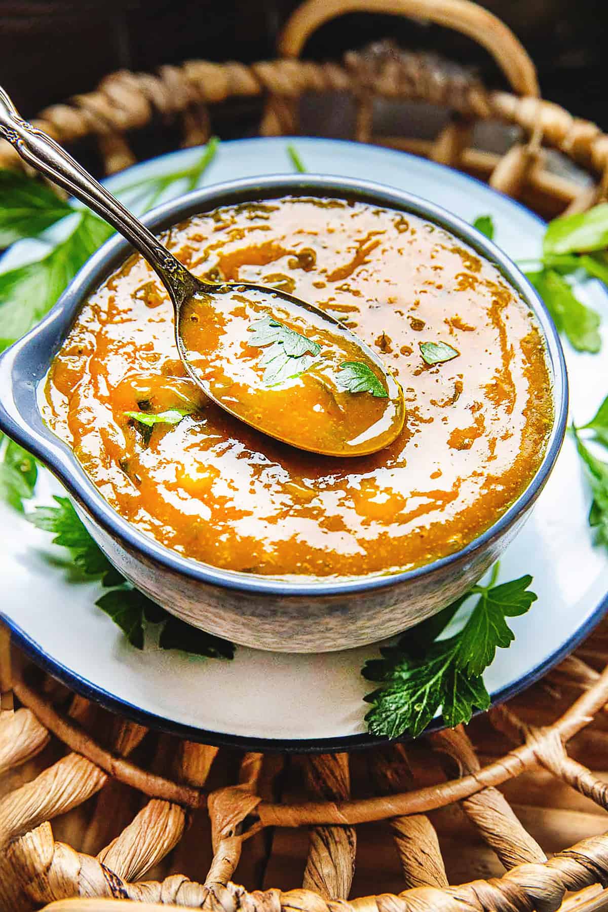 A bowl of Mango Curry Dipping Sauce on a plate on a basket tray.