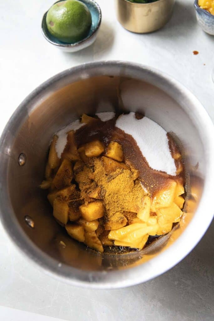 Ingredients for mango curry sauce are in a pot on the table. 