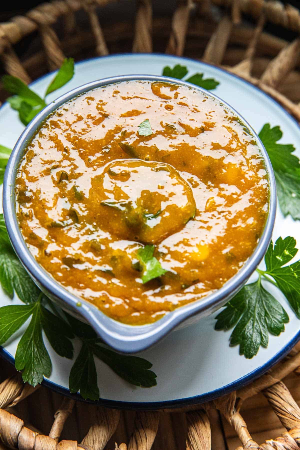A bowl of mango curry sauce on a plate on the table. 