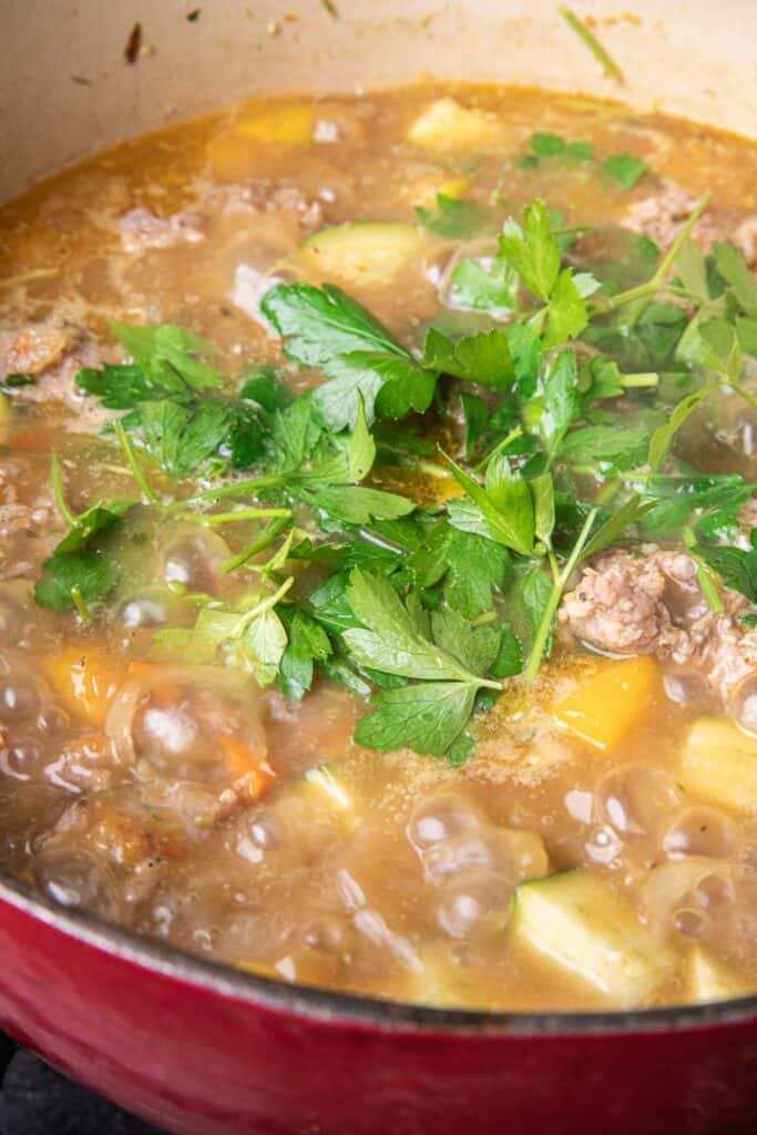  Cilantro garnish in a pot of chopped pumkin on the stove. 
