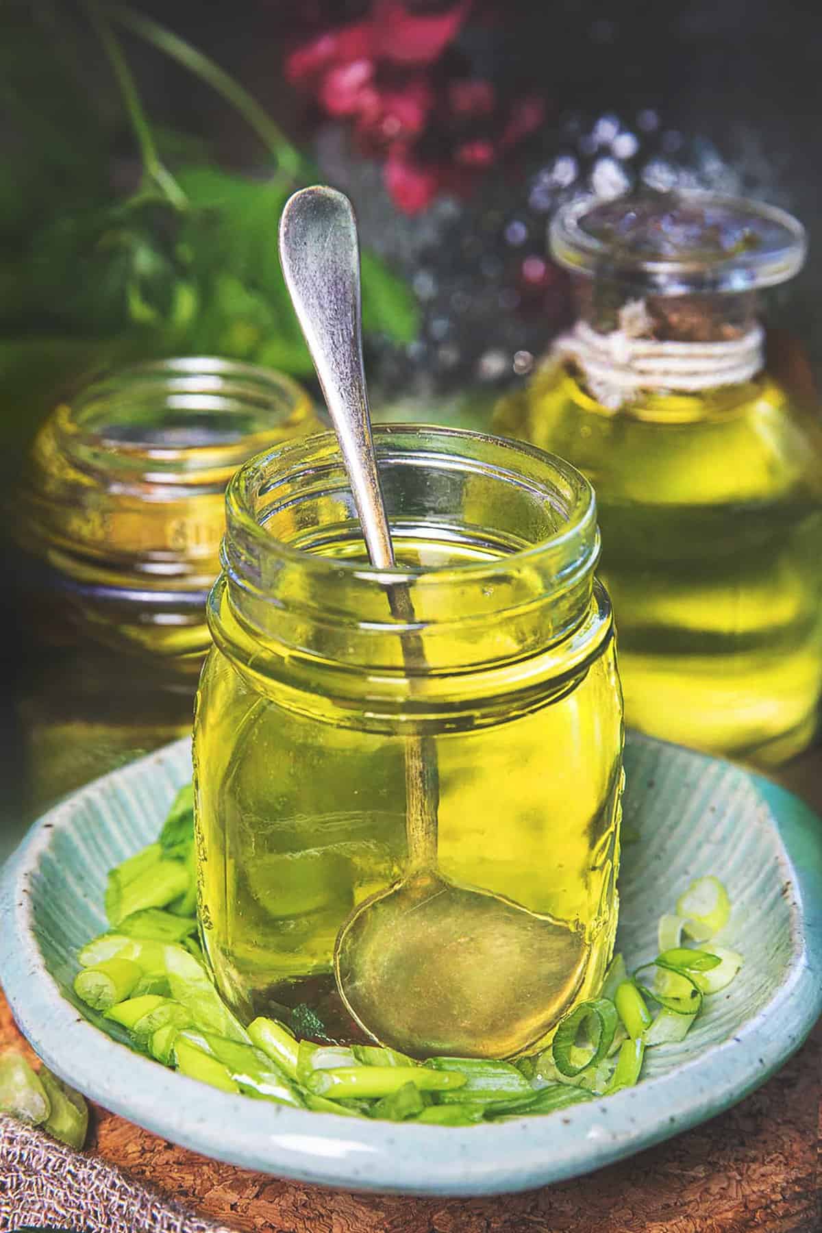 Fried scallions in a mason jar with a spoon inside. 