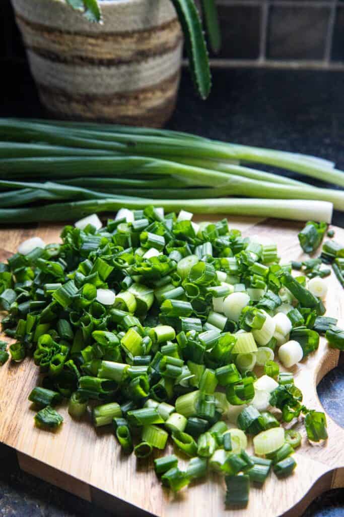 Chopped green onions on a cutting board.