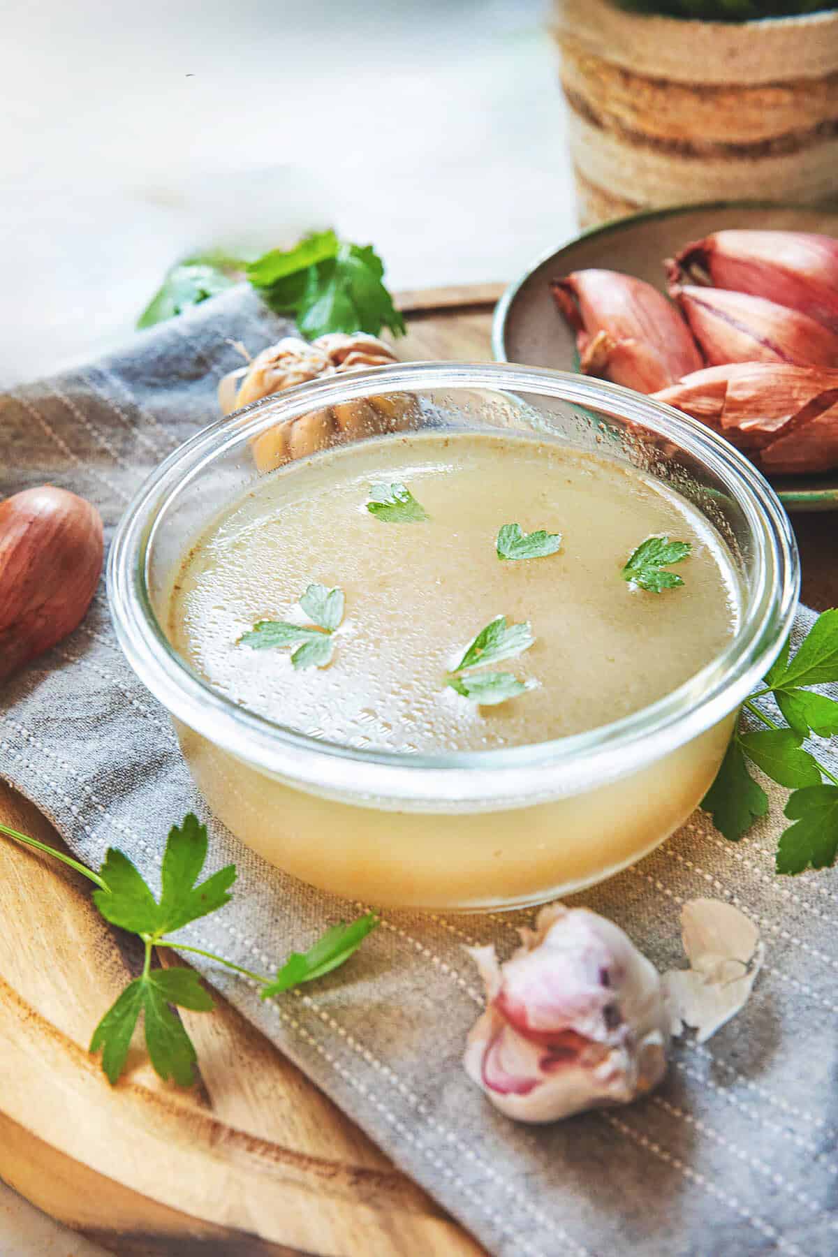 A bowl of thai pork stock in a clear bowl on top of a table. 